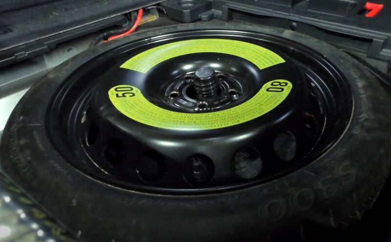 A car tire featuring a prominent yellow sticker attached to its side